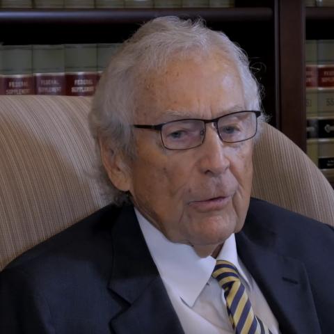 Justice Houston seated in front of books